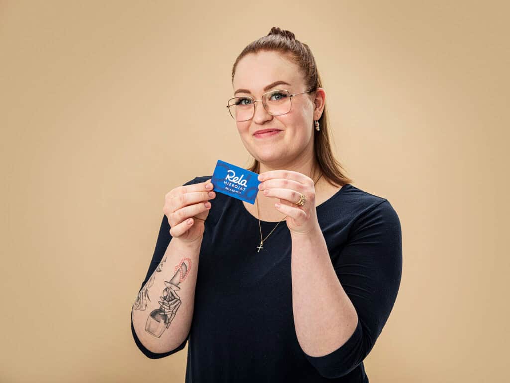 Hymyilevä nainen pitelemässä Relakorttia.