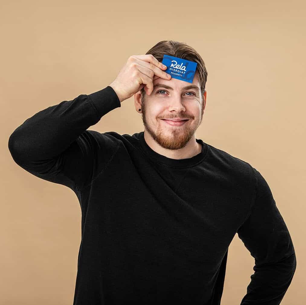 Hymyilevä mies pitelemässä Relakorttia kädessään.